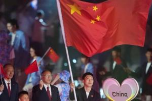 媒体人晒照：胡明轩担任中国队亚运代表团旗手举着国旗入场